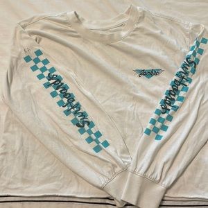 White long sleeve with checkered sleeves… it’s technically cropped but not a lot